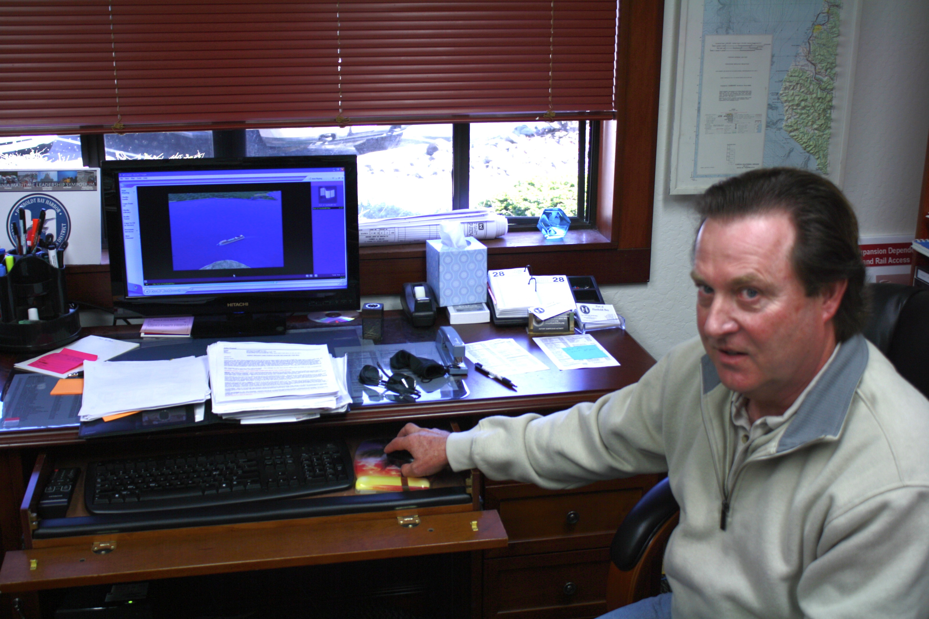 Captain John Powell spends more time than he'd like his desk. His computer is running an educational simulation he helped create, of a ship entering Humboldt Bay. - PHOTO BY ZACH ST. GEORGE