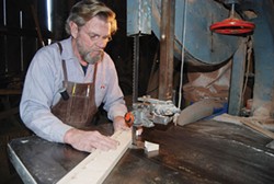 PHOTO COURTESY OF BLUE OX MILLWORKS - Craftsman Eric Hollenbeck, of Blue Ox Millworks, cutting an upper trim detail.