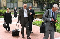 Defense attorney James Brosnahan (center, bald) and MAXXAM Chief Charles Hurwitz (behind Brosnahan) leave the Oakland Federal Courthouse Monday, which turned out to be the last day of the trial.  Photo by John Geluardi