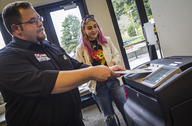 Clerk Jesse Hoskins casts a ballot into a voting machine at the Humboldt State University polling station. - MANUEL J. ORBEGOZO