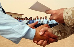 Right rules! A newly-graduated Iraqi policeman gets a congratulatory right-handshake from a U.S. Marine commandant while receiving his certificate with the left hand. Cpl. Paula Fitzgerald, Public Domain