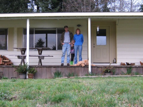 Scott and Linda Powell with their daughter and the family dog on the porch of their Dow's Prairie Mobile Home. - PHOTO COURTESY OF THE PACIFIC LEGAL FOUNDATION