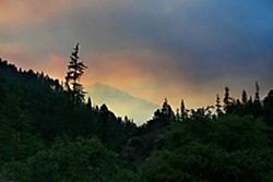 Smoke from the Jake and Portuguese fires hangs in the air over the Salmon River road at dusk. Photo by Yulia Weeks