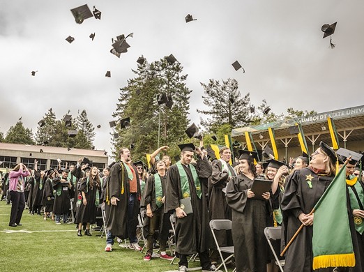 The tradition continues – graduates toss their mortarboard hats in the air to celebrate graduating after the Arts, Humanities & Social Sciences Commencement 2015 at Humboldt State University on Saturday, May 16. - MARK LARSON