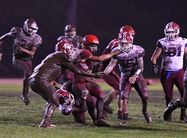 McKinleyville Panther running back Caleb Martinez is swarmed by Hoopa Warrior defenders. It was a wet and muddy affair as the Warriors took advantage of a slick field to pound out a win over the homecoming-celebrating McKinleyville Panthers 22-12 Saturday night. - CANDICE LACKEY