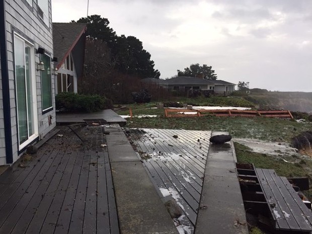 A fence was knocked down between these two waterfront homes and waves left debris on deck of the home in the foreground. - CHERYL ANTONY OF SHELTER COVE FIRE