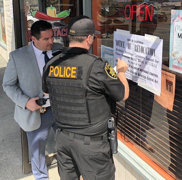 An agent with the California Department of Alcoholic Beverage Control posts a notice of revocation at Rico's Tacos. - SUBMITTED