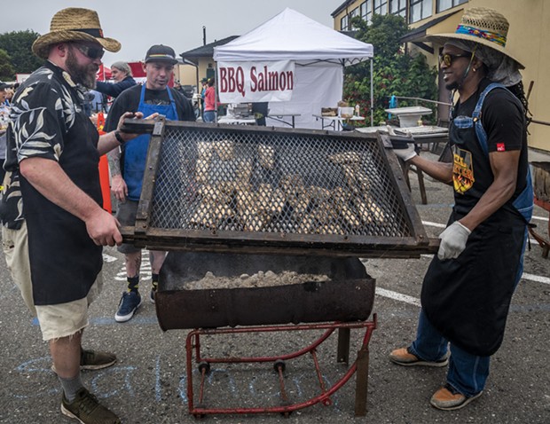 Pitmaster John McClurg (Left) and volunteers Ryan (middle) and Gilbert helped wrangle the grilled salmon. - PHOTO BY MARK LARSON