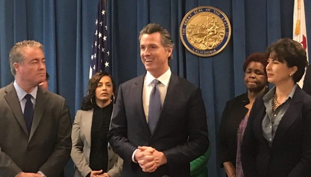 Gov. Gavin Newsom, flanked by authors Sen. Connie Leyva and Assemblyman Patrick O’Donnell, prepares to sign a charter school transparency bill earlier this year. - PHOTO FOR CALMATTERS BY RICARDO CANO