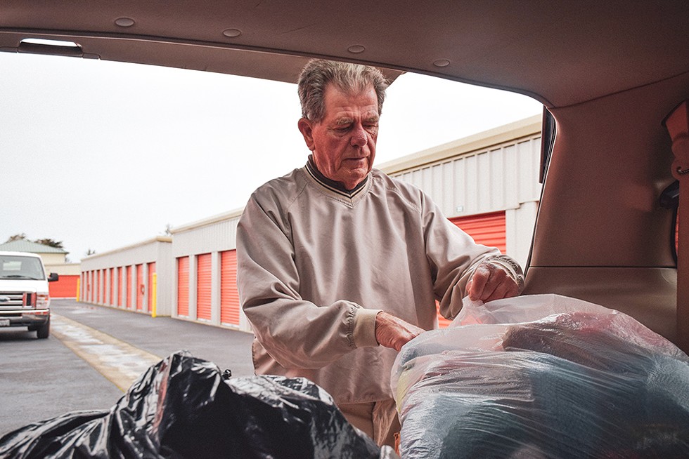 Robert Lohn pulls bags of coats from the back of his minivan - PHOTO BY THADEUS GREENSON