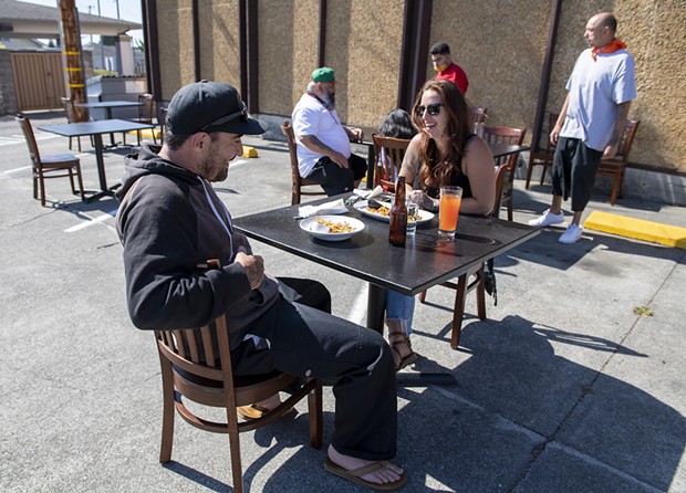 Head chef of Five Eleven Josh Wiley and his girlfriend Cheyanne Samson enjoyed empanadas int the ersatz parking lot cafe. - PHOTO BY MARK MCKENNA