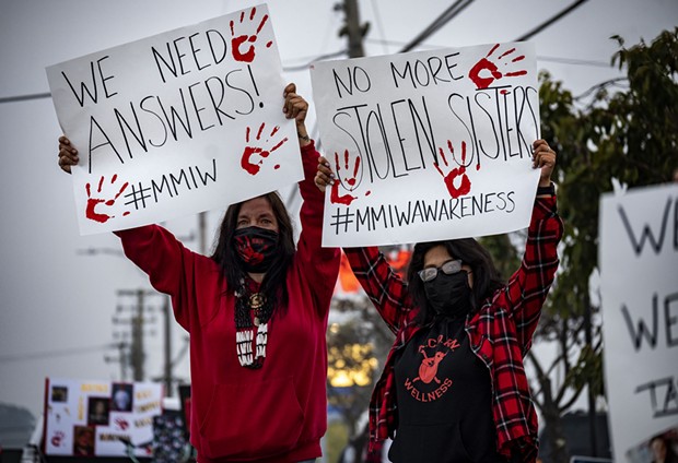 Yvonne Guido (left) and Wakara Scott (right) stand holding signs reading “We need answers!” and “No more stolen sisters,” respectively at the Missing and Murdered Indigenous Peoples rally at the federal building in Fortuna. - KRIS NAGEL