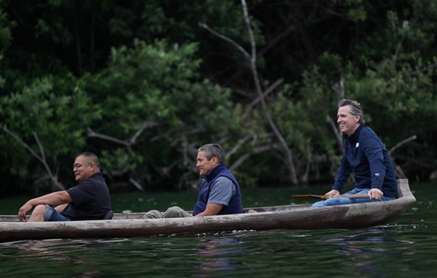 Yurok Chair Joseph L. James, California Natural Resources Secretary Wade Crowfoot and Gov. Gavin Newsom travel in a traditional redwood canoe down the Klamath River on the Yurok Reservation. - SUBMITTED