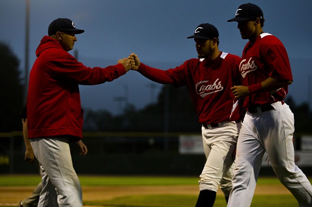 Crabs pitcher Wesley Harper (No. 32) fist-bumps with Crabs Manager Robin Guiver after completing an inning of work while heading back to the dugout on July 9, 2021. - THOMAS LAL