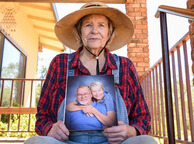 Johanna Trenerry of Happy Valley holds a photograph of herself with her husband, Art Trenerry, who died last year of COVID-19 while staying at Windsor Redding Care Center. His family members, including Johanna, are named as plaintiffs in a lawsuit against the facility. - PHOTO BY MATT BATES FOR CALMATTERS