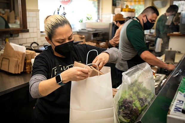 Roxanna Torres prepares to-go meals at Baker & Commons in Berkeley on Jan.19, 2022. - PHOTO BY MARTIN DO NASCIMENTO/CALMATTERS