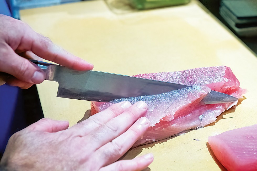 Talbert breaks down some Hawaiian albacore as he preps for service. - PHOTO BY MARK MCKENNA