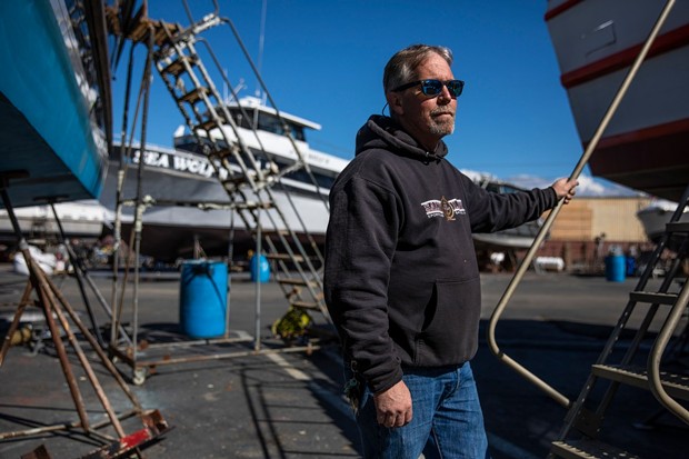 Jared Davis stands beside his charter fishing boat, Salty Lady, as it sits in dry dock in Richmond on Mar. 8, 2023. - PHOTO BY MARTIN DO NASCIMENTO, CALMATTERS