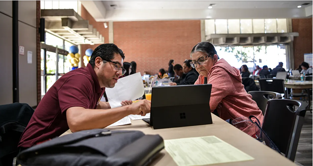 Isaias Hernandez, executive director of the Eastmont Community Center, helps a person with their taxes during a free tax preparation event at the Nakoak Community Center in Gardena on April 1, 2023. - PHOTO BY PABLO UNZUETA FOR CALMATTERS