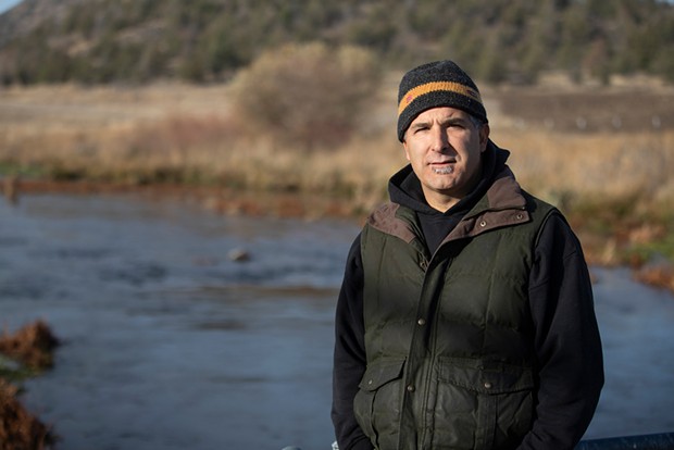 California Department of Fish and Wildlife Klamath and Trinity Rivers Program Supervisor Morgan Knechtle stands on a bridge overlooking the Big Springs Creek flowing into the Shasta River. - PHOTO BY LARRY VALENZUELA, CALMATTERS/CATCHLIGHT LOCAL