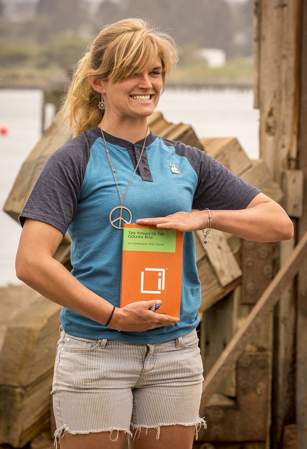 Long-time volunteer and self-described "jack-of-all trades" Libby Tonning, of Manila, poses with one of the books about the Golden Rule prior to its launching at the Zerlang & Zerlang boat yard on the Samoa peninsula. - MARK LARSON