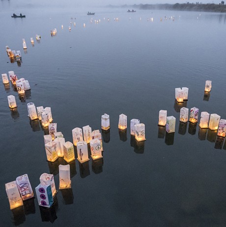 Personalized paper lanterns drift out onto Klopp Lake on Saturday night. - MARK LARSON