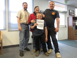 Three generations of growers, Rain on the Earth with her nephews Mark Switzer (far right) and grand-nephew Myles Moscato (center) pose with Wall as Moscato proudly holds the receipt for his application, the first submitted in the county. - LINDA STANSBERRY