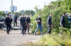 Officers prepare to enter the marsh on May 2, 2016. - FILE