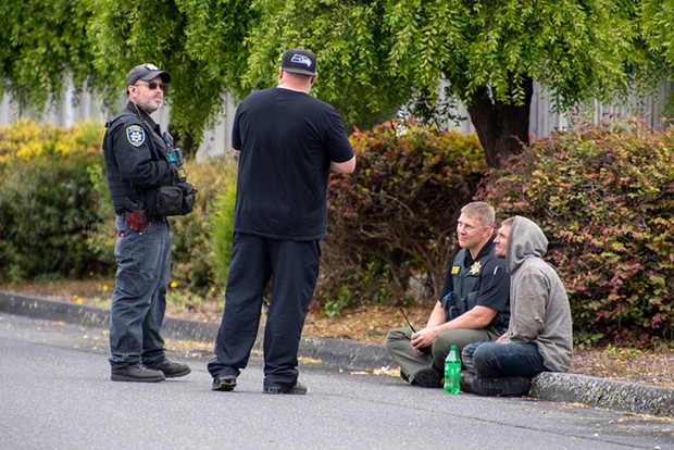 Undersheriff Justin Braud sits with wanted fugitive Matthew Dilley moments after Dilley surrendered his pistol, concluding an hours-long standoff with police in McKinleyville.