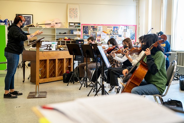 Jo Kuzelka conducts a music class at St. Bernard's High School, where students don't share stands and only play mask-compatible instruments.