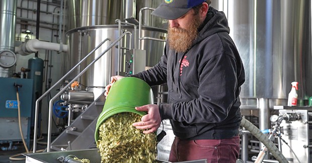 Mad River brewer Ross McCabe adds dry hops to a batch of Steelhead IPA.