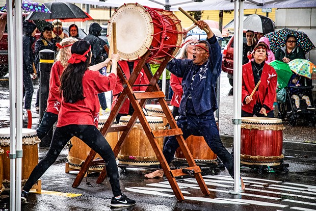 Humboldt Taiko, led by Gary Ronne (center), found refuge from the rain under a large tent for their performance leading off the Eureka Chinatown Street Festival program.
