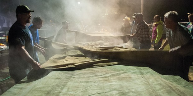 Tarps are spread over the smoking covered barbecue pits at the Fortuna Rodeo.