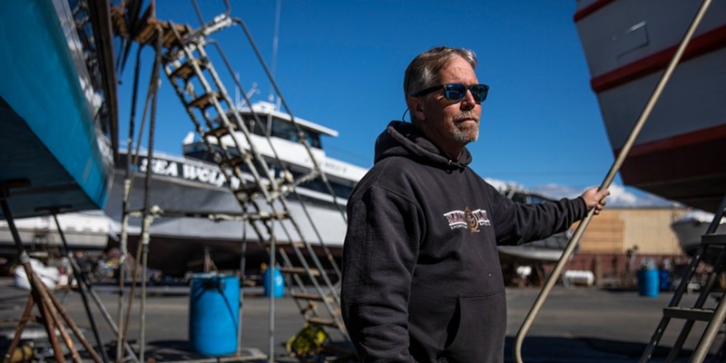 Jared Davis stands beside his charter fishing boat, Salty Lady, as it sits in dry dock in Richmond on Mar. 8, 2023.