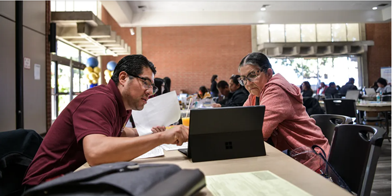 Isaias Hernandez, executive director of the Eastmont Community Center, helps a person with their taxes during a free tax preparation event at the Nakoak Community Center in Gardena on April 1, 2023.