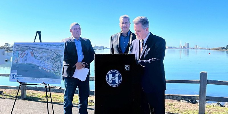 Jeff Andreini (right), Crowley’s former president of new energy, signs a deal to launch exclusive negotiations to develop and operate an offshore wind port on the Samoa Peninsula as Humboldt Bay Harbor District Board Chair Greg Dale (left) looks on.