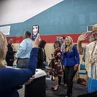Wiyot tribal elder Cheryl Seidner (right) waves hello to Eureka City Councilmember Natalie Arroyo, who was watching the ceremony via Facetime (with a little help from Eureka Executive Assistant Christine Tyson) while deployed on active duty orders with the U.S. Coast Guard in Georgia.
