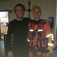 Petty Officer 2nd Class Michael Hernon, a Coast Guard Sector Humboldt Bay rescue swimmer, stands with Kris Nagel, a distressed surfer who was rescued by the Coast Guard when he was reportedly swept toward rocks near Moonstone Beach while he was surfing, Dec. 15, 2019. A Sector Humboldt Bay MH-65 Dolphin helicopter crew was dispatched to the scene, hoisted Nagel into the helicopter and took him to California Redwood Coast - Humboldt County Airport where he was transferred to emergency medical services personnel.