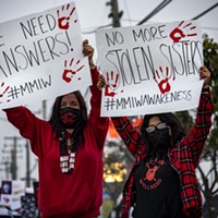 Yvonne Guido (left) and Wakara Scott (right) stand holding signs reading “We need answers!” and “No more stolen sisters,” respectively at the Missing and Murdered Indigenous Peoples rally at the federal building in Fortuna.
