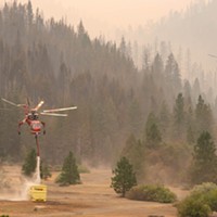 A Sikorsky helicopter refills its tank at a dip point whole working the McFarland Fire.