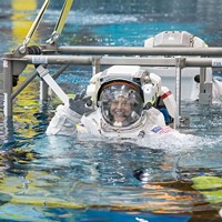 NASA astronaut Nicole Mann is lowered into the Neutral Buoyancy Laboratory during a spacewalk training session in 2014.