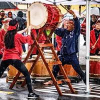 Humboldt Taiko, led by Gary Ronne (center), found refuge from the rain under a large tent for their performance leading off the Eureka Chinatown Street Festival program.