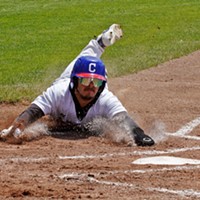 Victor Castaneda slides in safe at home during a high scoring day for the Crabs.