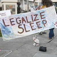 Carla Ritter, left, and Carlene "CC" Schultz, both of Fieldbrook, hold a banner supporting the decriminalization of sleeping in public. Schultz says she spent a year houseless in Humboldt County before getting a home. She said she had also been a "street mom" for eight to 10 years helping kids on the street and others when she had an RV.