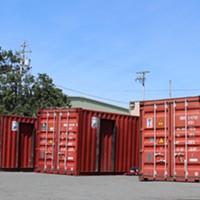 Shipping containers sit in the lot at the corner of Third and Commercial Streets, with renovations having already begun.