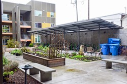 PHOTO BY THADEUS GREENSON - An enclosed patio features raised garden beds and seating areas.
