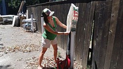 SUBMITTED PHOTO. - Holly Carter cleans bags with a leaf blower.