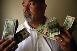 PHOTO BY FRANCINE ORR/LOS ANGELES TIMES - A Mendocino County district attorney investigator holds $45,000 in seized cash.
