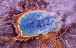 PHOTO COURTESY JIM PEACO, NATIONAL PARK SERVICE - Huge mats of orange algae and bacteria surround Yellowstone's Grand Prismatic Spring in this aerial photo. "Extremophiles" like this could be the model for bioengineering life suited to extraterrestrial conditions.