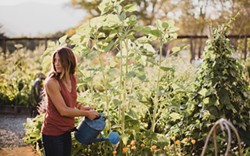 PHOTO BY WEST CLIFF CREATIVE - Emily Murphy in her garden with sunflowers and calendula.